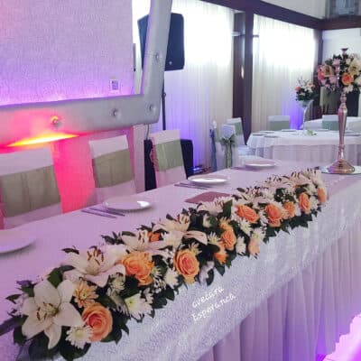 Ikebana za mladenački sto, dva svećnjaka na krajevima stola – niz od ruža, ljiljana, hrizantema
